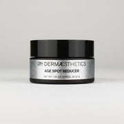Dermaceutical jar labeled 'Age Spot Reducer' on a light gray background