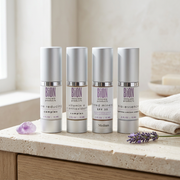 Four BiON Renew & Protect Kit silver bottles on pale stone beside ivory linen and lilac accents