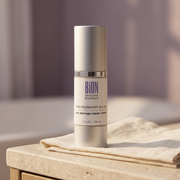 BiON Bio-Replenish A-C-E silver bottle on ivory linen and a stone vanity