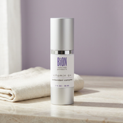 BiON Vitamin A+ Antioxidant Complex silver bottle on pale stone vanity beside folded ivory linen