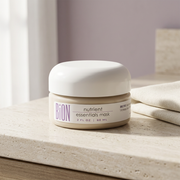 BiON Nutrient Essentials Mask jar on pale stone vanity beside folded ivory linen